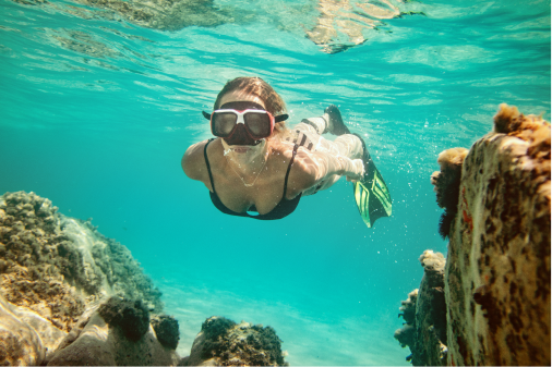 A girl snorkeling through the coral reef